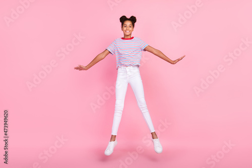 Full body photo of brown bun haired stylish trendy african american girl wear casual outfit jump isolated on pink color background