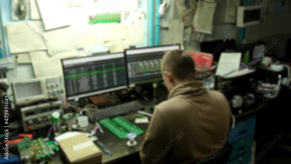 Blurred background, unrecognizable people, professional master repairs electronics. Slow motion. Blurred background, unrecognizable people, professional master repairs electronics. Slow motion.
