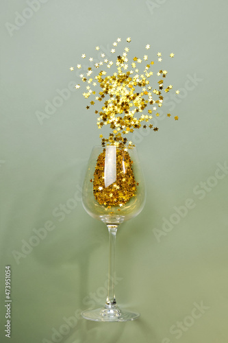 wine glass with scattered golden star glitter