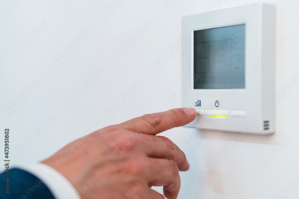 Businessman operating office automation on wall Businessman operating office automation on wall