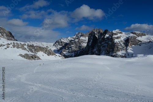 Silhouettes of skiers during backcountry skis through snowy mountains on a sunny day. Silhouettes of skiers on trail. During trip in Dolomites around Tre Cime. Sexten Dolomites, South Tyrol, Italy