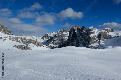 Silhouettes of skiers during backcountry skis through snowy mountains on a sunny day. Silhouettes of skiers on trail. During trip in Dolomites around Tre Cime. Sexten Dolomites, South Tyrol, Italy