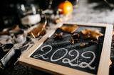 Baking Christmas gingerbread cookies on a dark wooden table. Preparing for baking. Winter holidays. 2022 New Year sign. Top view. 