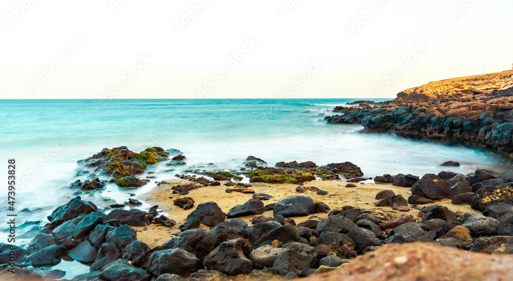beautiful sunset on the beach of the island of gran canaria with beautiful lights silky water and wonderful sunset scenery of the canary islands in paradisiacal beaches