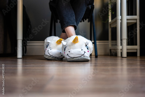 Woman wearing fluffy slippers with legs crossed at ankle at home photo