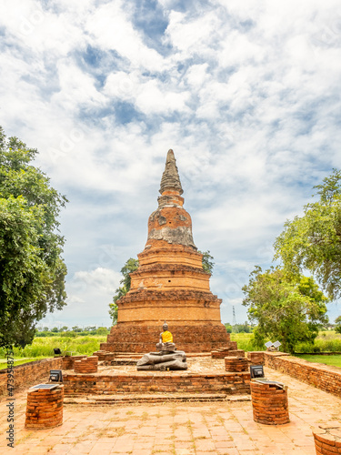 Old brick pagoda in ancient temple in Ayutthaya, old capital city of Thailand, UNESCO World heritage place, under cloudy blue sky in summer
