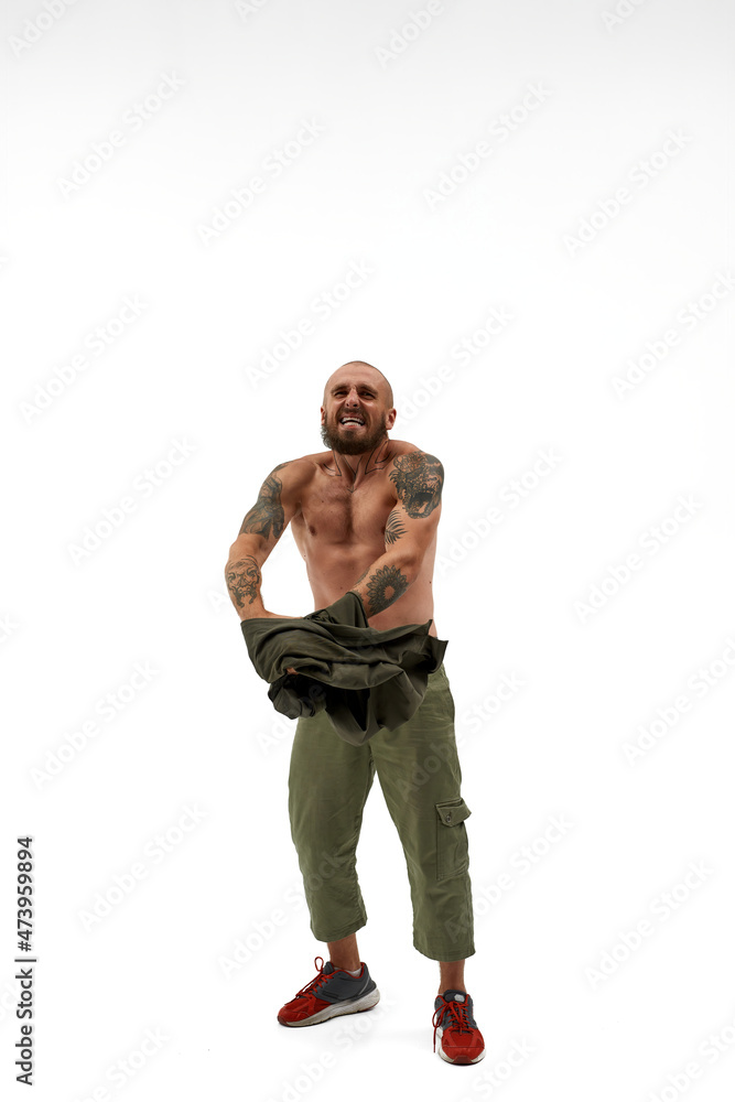 Angry man holding tank top and looking at camera Angry man holding tank top and looking at camera