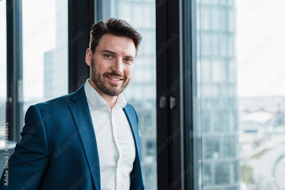Smiling male entrepreneur in blazer at work place Smiling male entrepreneur in blazer at work place