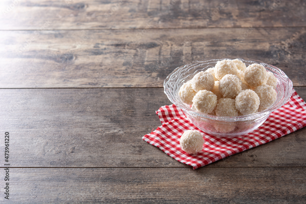 Homemade coconut balls in crystal bowl on wooden table Homemade coconut balls in crystal bowl on wooden table
