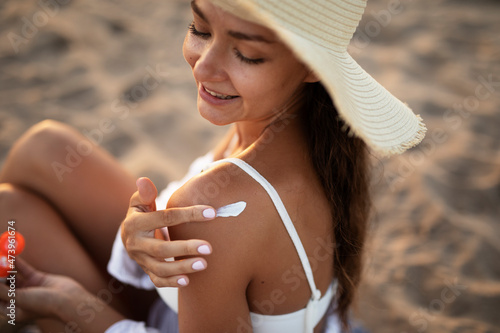 Woman using sunscreen cream. Beautiful girl with sun protection cream