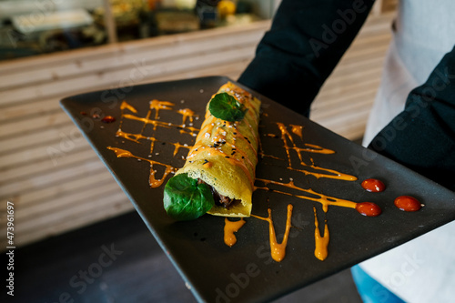 Chef holding plate of cannelloni in restaurant photo