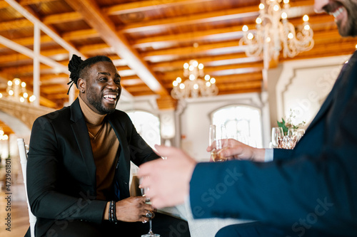 Cheerful male friends sitting and enjoying at banquet photo
