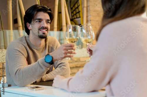 Man raising toast with girlfriend at restaurant photo
