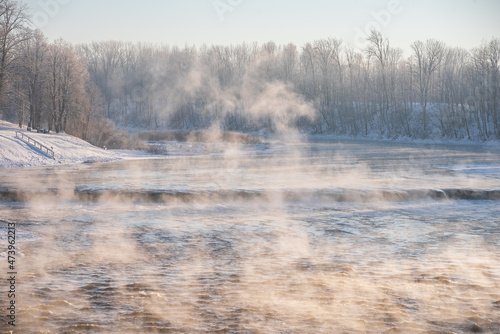 Venta river waterfall in the fog in cold, sunny winter morning, Kuldiga, Latvia