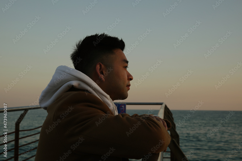Silhouette of asian man standing against nature landscape in deep thought Silhouette of asian man standing against nature landscape in deep thought