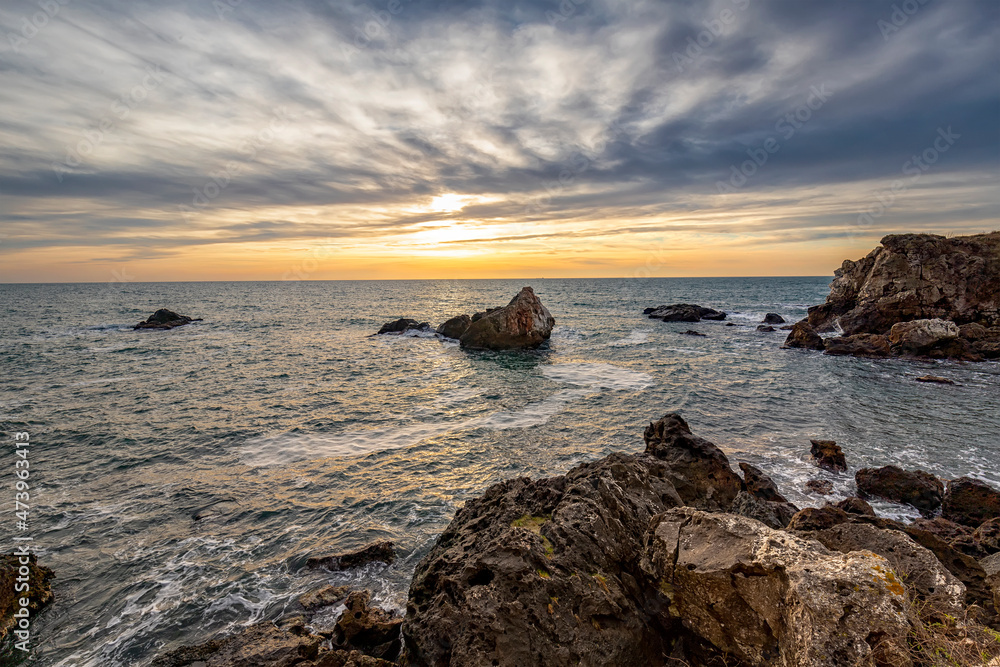 Stunning seascape with scenic clouds over the sea with big rocks Stunning seascape with scenic clouds over the sea with big rocks