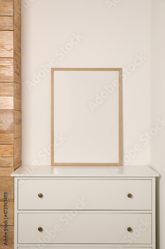 Blank frame on chest of drawers indoors. Space for design