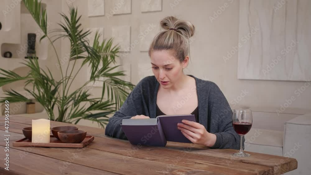 Young worry sad caucasian woman read book. Home wooden warm apartment Young worry sad caucasian woman read book. Home wooden warm apartment