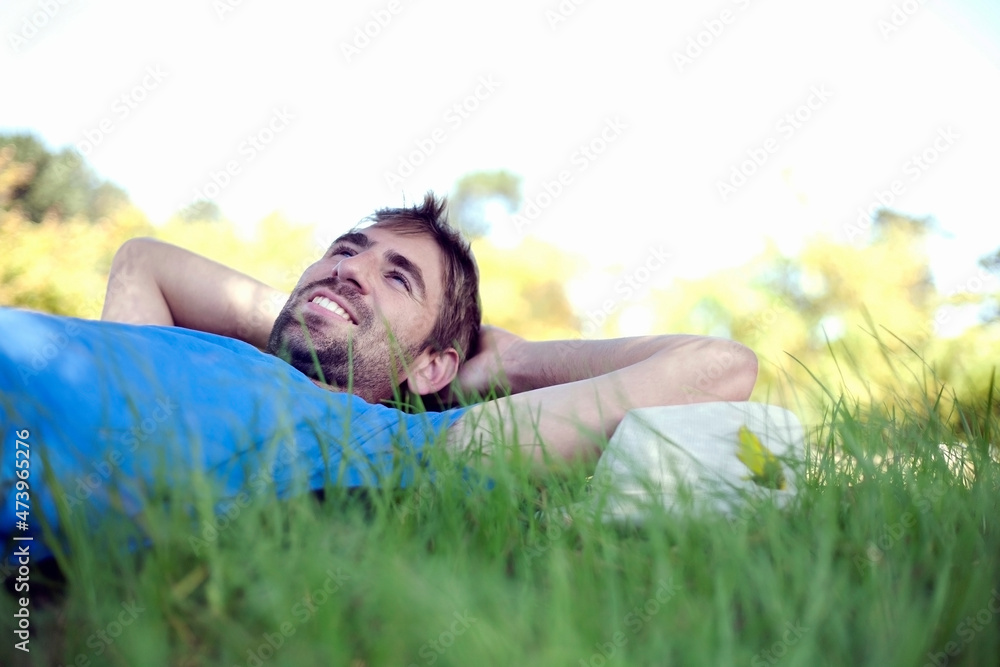 Young man contemplating while lying on grass at park Young man contemplating while lying on grass at park