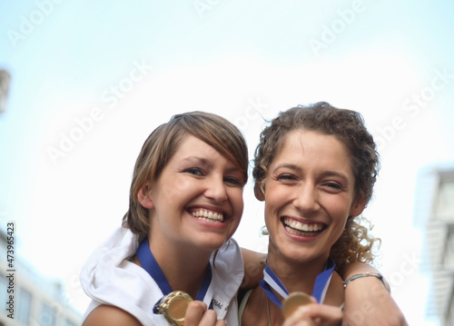 Happy female athletes wearing medals photo