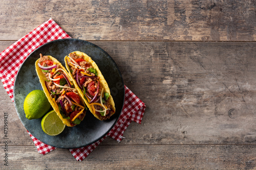 Traditional Mexican tacos with meat and vegetables on wooden table. Top view. Copy space