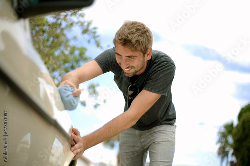 Smiling young man polishing car photo
