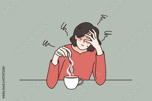 Exhausted young woman sit at table drink coffee feel fatigue or drowsiness. Tired female suffer from overwork lack energy need caffeine. Overwhelmed with work. Flat vector illustration. 