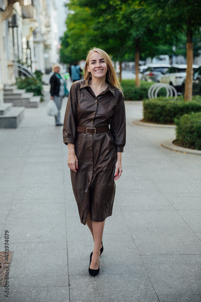 Fototapeta premium woman in a brown cape on the streets of the city
