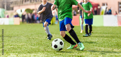 Group of chool Kids Running Football Ball and Compete in School Soccer Tournament. Boys in Sports Jersey Running on Grass Field and Kicking Ball