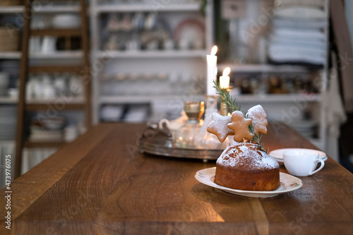 Christmas cake on a wooden table and lit candles
