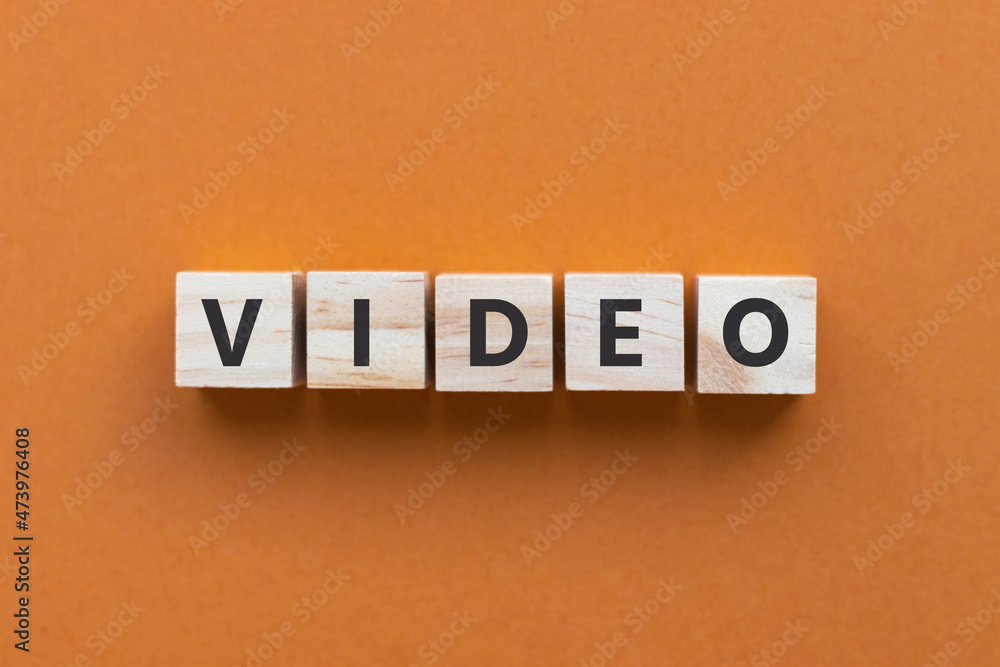 Text VIDEO on wooden cubes on orange background. Wood blocks. Top view, flat lay. Text VIDEO on wooden cubes on orange background. Wood blocks. Top view, flat lay.