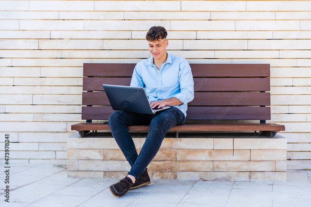 Businessman using laptop while sitting on bench Businessman using laptop while sitting on bench