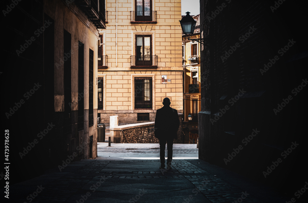 Silhouette of adult man on a narrow street of city. Shot in Madrid, Spain