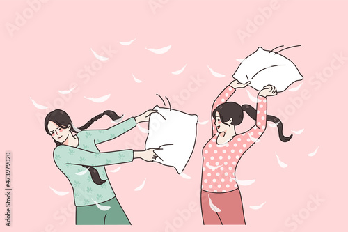 Happy girlfriends have fun beat with pillows at pajama party at home. Smiling girls feel crazy with pillow fight at domestic sleepover on weekend. Friendship concept. Flat vector illustration. 