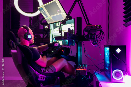 Male gamer playing video game at studio photo