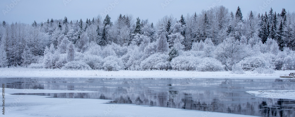 Obraz premium River in a cold winter landscape with snow and frost