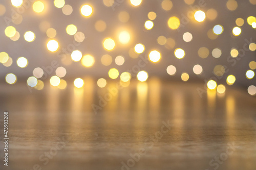 Side view of bokeh of christmas lights and empty brown wooden table for product presentation