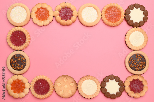 Frame made of different cookies on pink background
