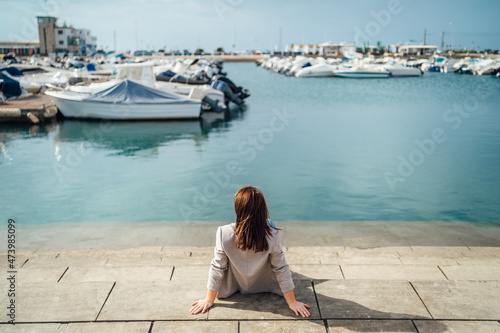 Portrait of young woman sitting by the marina © eunikas