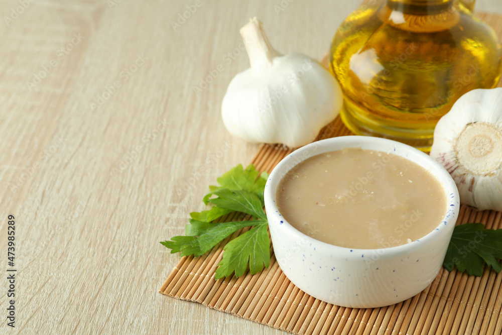 Concept of tasty food with tahini sauce on light wooden background Concept of tasty food with tahini sauce on light wooden background