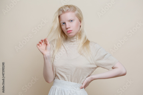 Cute albino girl  on a beige background. photo