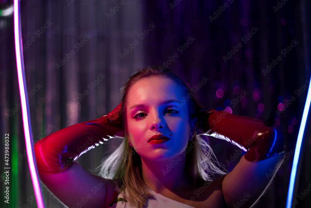 Naklejka premium Cinematic night portrait of girl and neon lights. Fashion. Woman in Colorful neon light. girl in disco, makeup dance. Party disco neon nightclub vibes. creative art neon pink blue light.