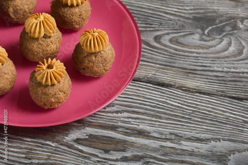 Banana cakes with butter cream. Lie on a plate. On black pine boards. Close-up shot.