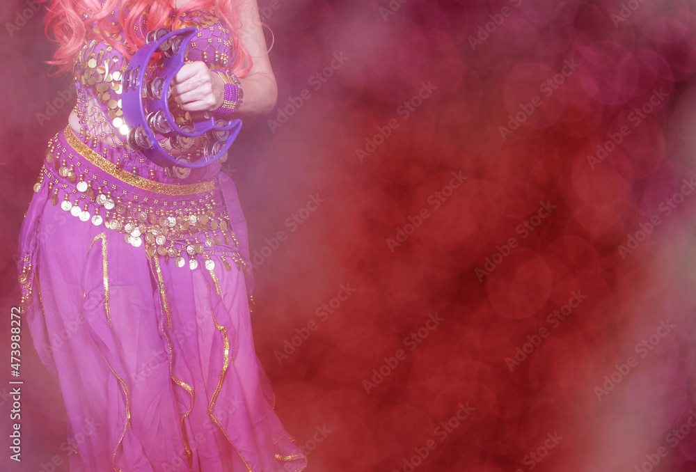 Belly Dancer wearing purple dance costume close up with bokeh Stock