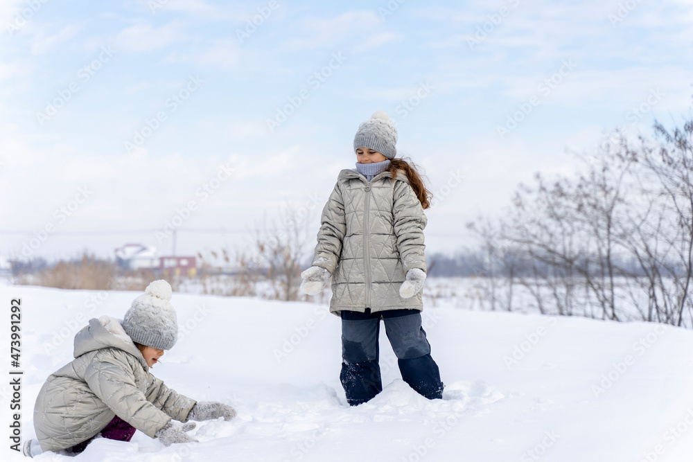 Happy children play snowballs, run, throw snow. Funny kids play games indoors in the winter with snow