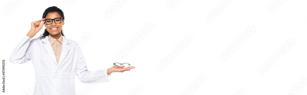 Young african american oculist holding and adjusting eyeglasses isolated on white, banner. Young african american oculist holding and adjusting eyeglasses isolated on white, banner.