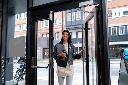 Smiling woman entering office