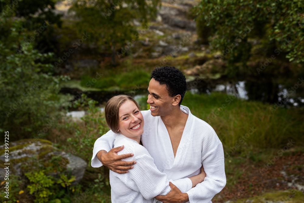 Young couple in bathrobes hugging and smiling Young couple in bathrobes hugging and smiling