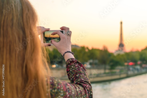 France, Paris, Woman taking photo with mobile phone photo