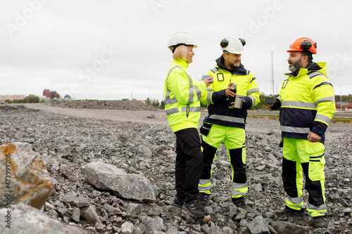 Engineers in reflective clothing having hot drink